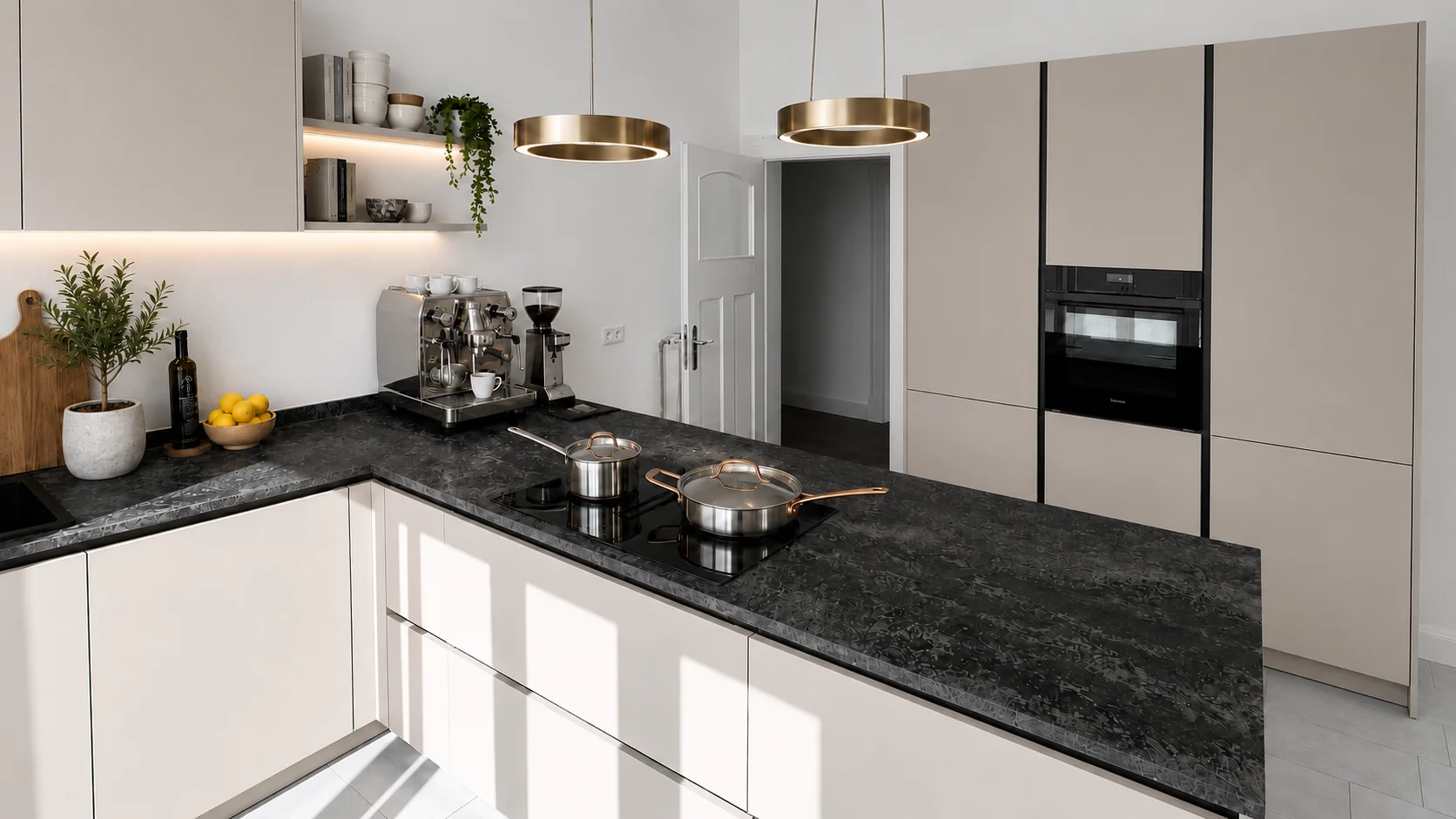 Fertig eingerichtete Einbauküche im Atelier der Villa Valentino mit schwarzer Granit-Arbeitsplatte, Induktionskochfeld, Espressomaschine und Messing-Pendelleuchten