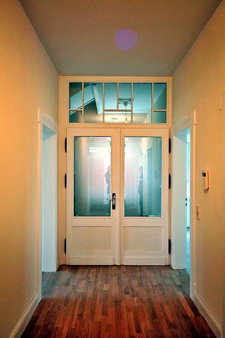 Wohnraum der Villa Valentino mit Echtholzparkett und restaurierter historischer Glas-Flügeltür