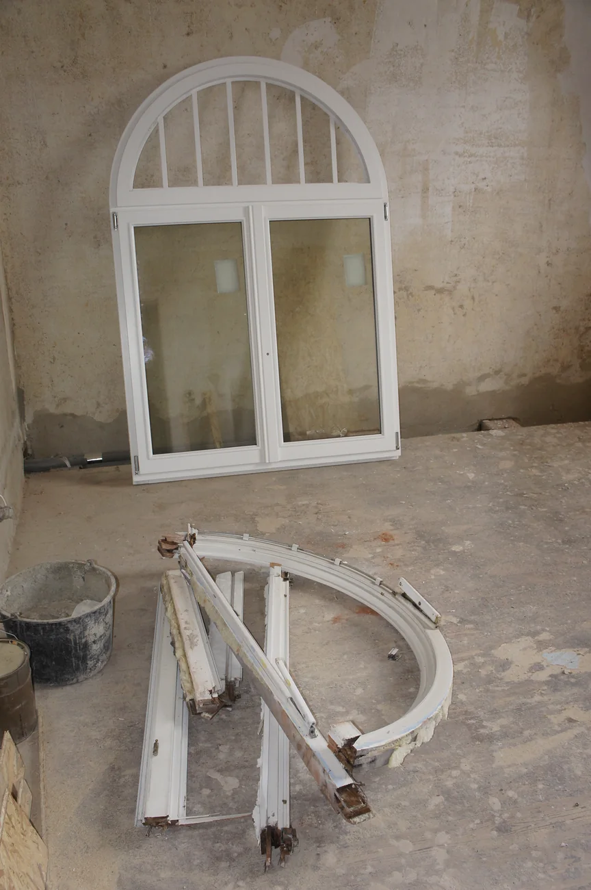 Neues Rundbogenfenster der Villa Valentino vor dem Einbau, daneben der ausgebaute alte Fensterrahmen