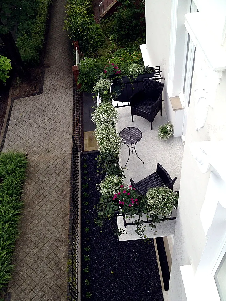 Der neu gestaltete Innenhof der Villa Valentino mit Hartholz-Terrasse und Natursteinpflaster