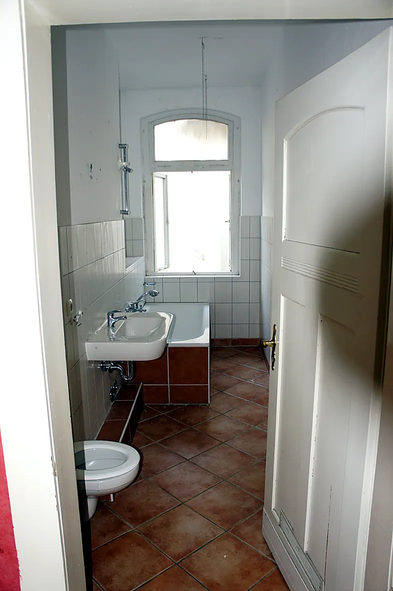 Der verwahrloste Hinterhof der Villa Valentino vor der Sanierung mit Gerümpel und Mülltonnen