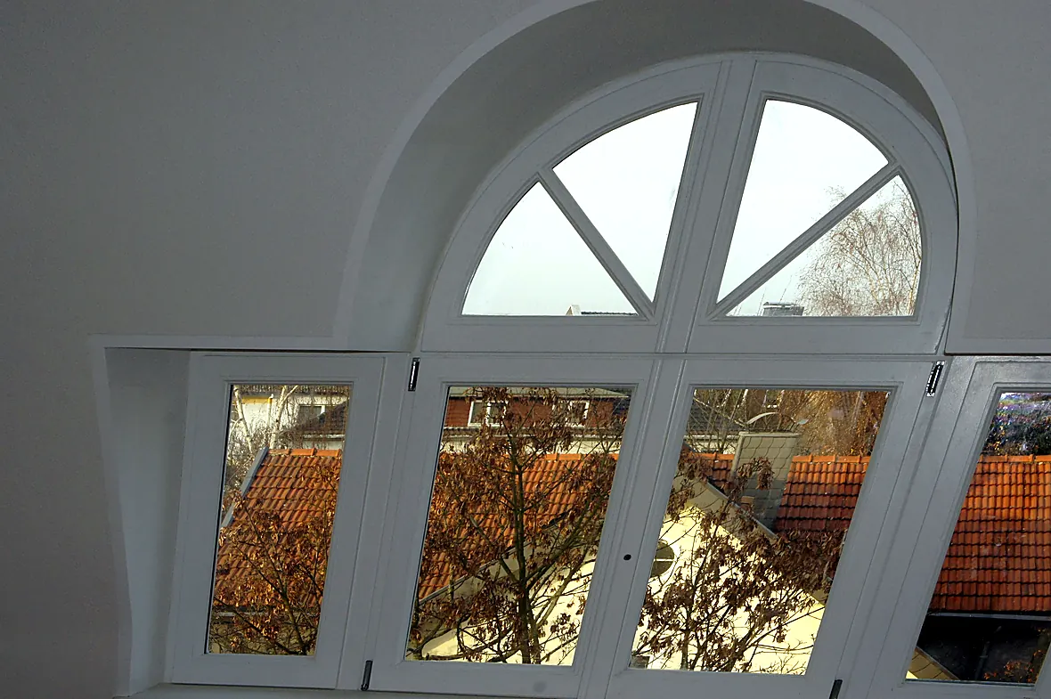 Restauriertes denkmalgerechtes Rundbogenfenster der Villa Valentino von innen mit Sprossen und Blick über die Dächer