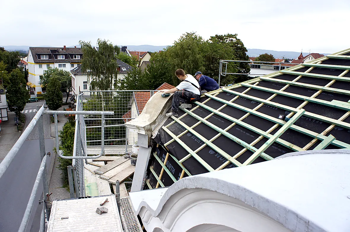Dachdecker beim Neuaufbau des Mansarddachs der Villa Valentino mit Unterspannbahn und Konterlattung