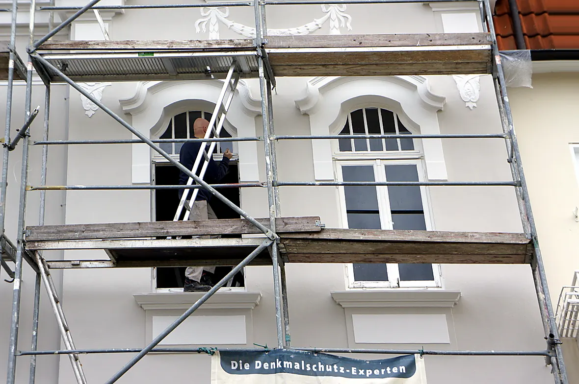 Einbau eines neuen denkmalgerechten Fensters an der Fassade der Villa Valentino mit Stuckgirlanden