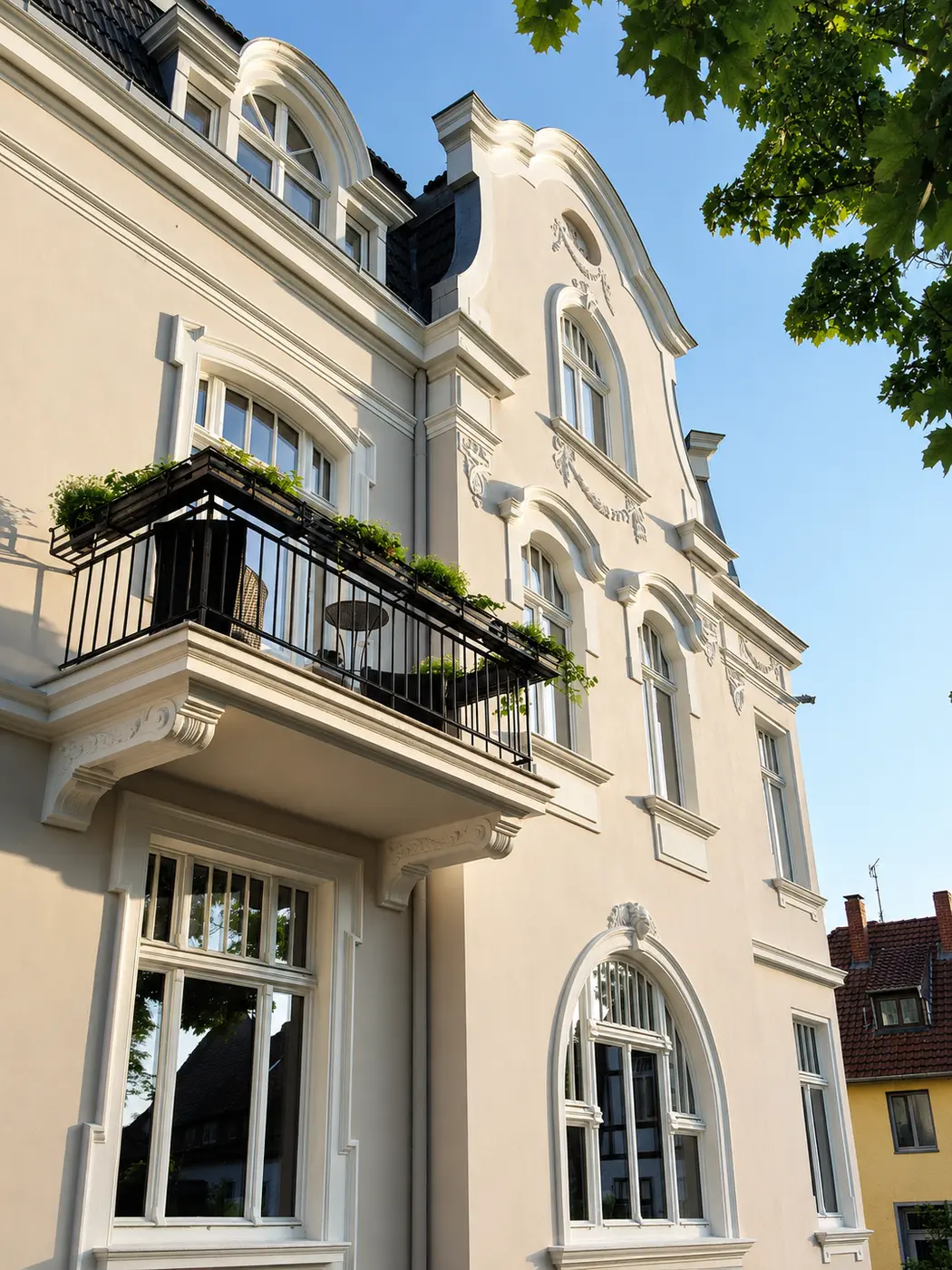 Villa Valentino im Abendlicht – Balkon mit schmiedeeisernem Geländer, Stuckrahmungen und Rundbogenfenster