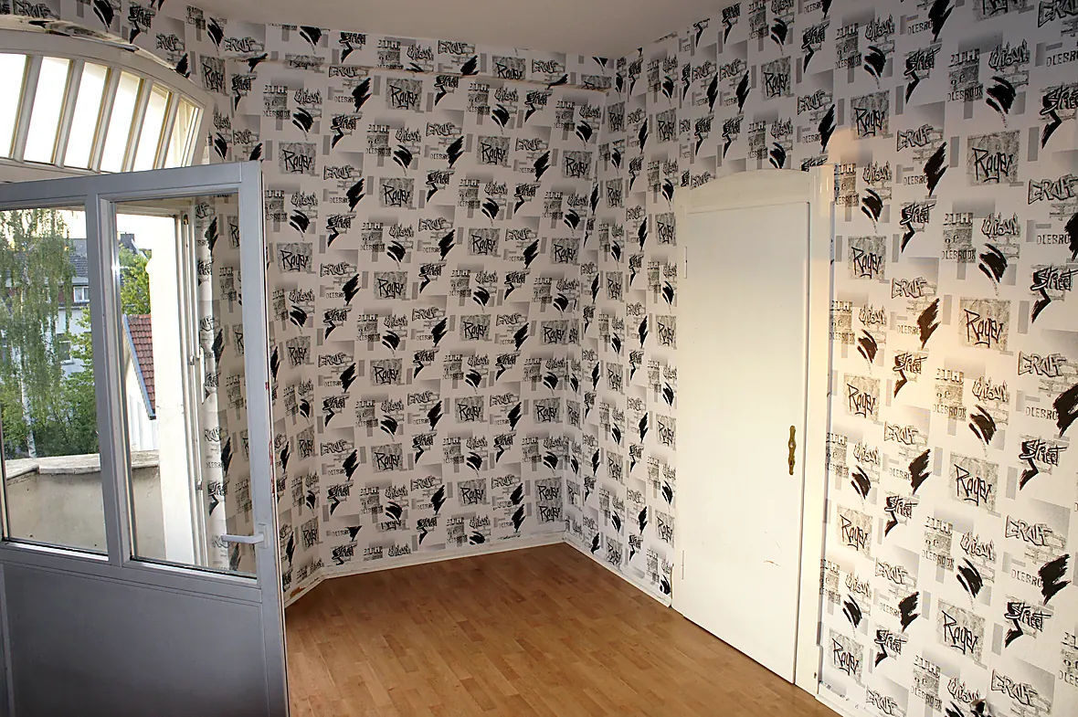 Jugendzimmer der Villa Valentino vor der Sanierung mit schwarz-weißer Graffiti-Tapete
