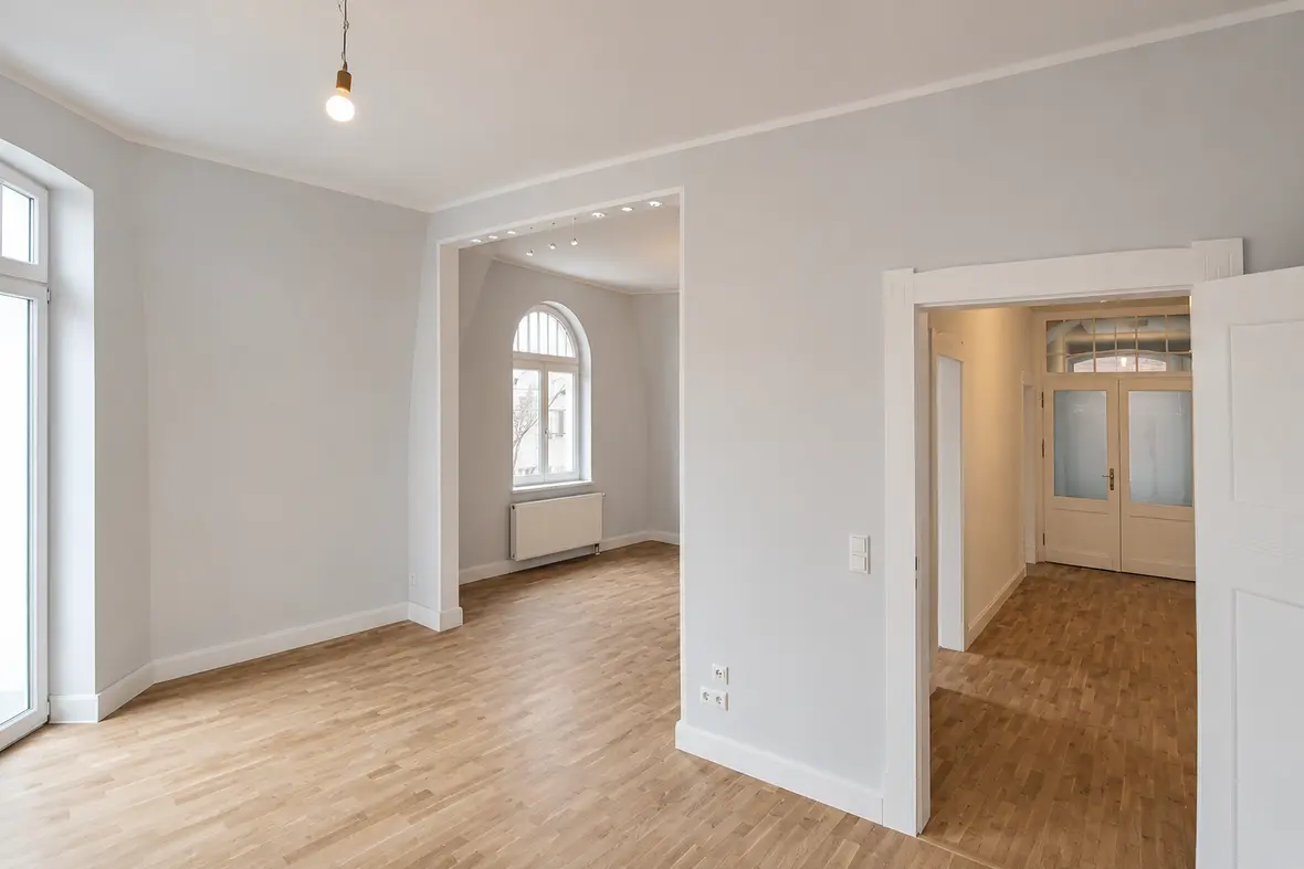 Wohnraum im 2. Obergeschoss der Villa Valentino mit restaurierten Flügeltüren und Rundbogenfenster